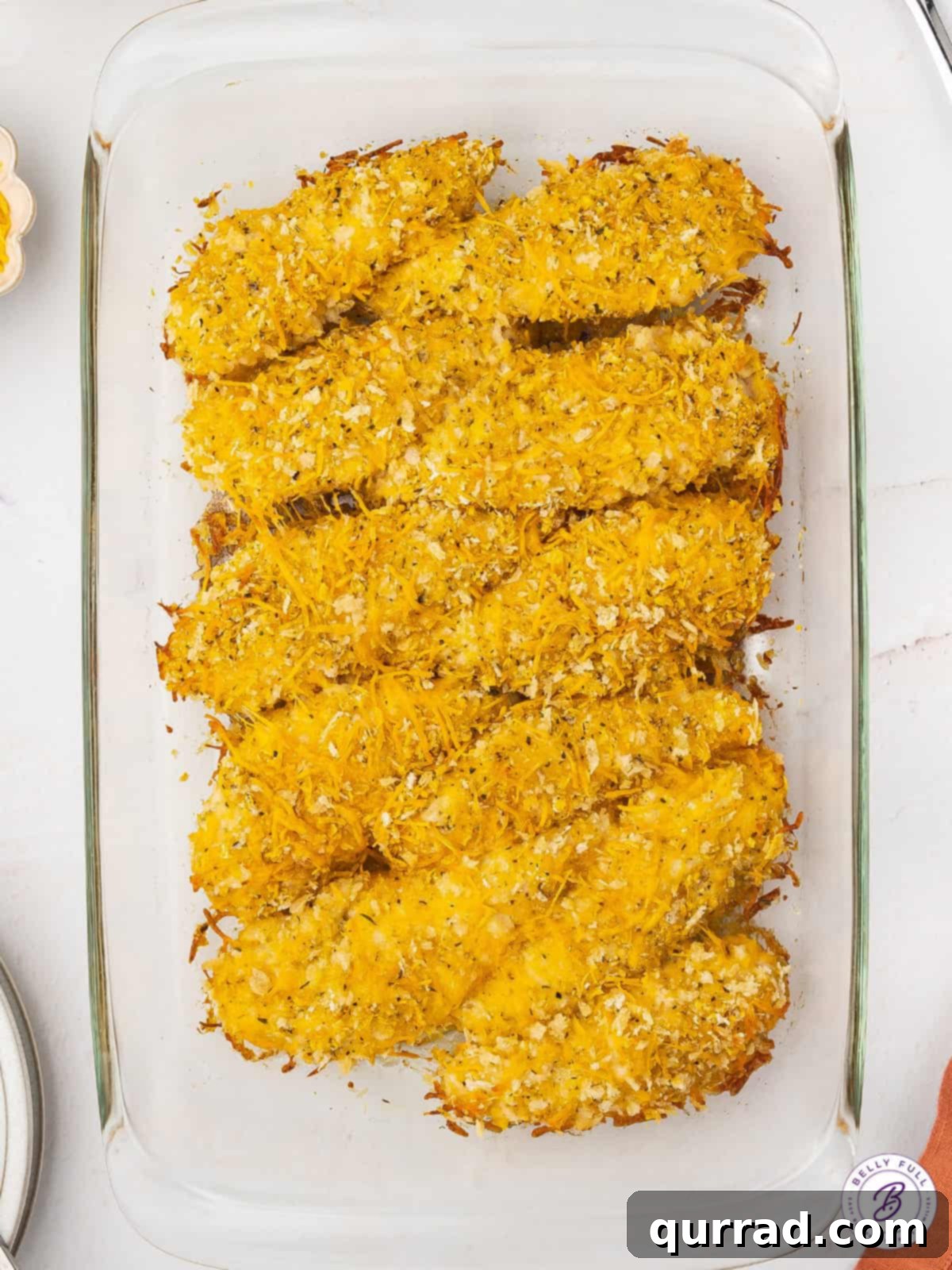 Cheddar baked chicken tenders in a casserole dish, fresh from the oven