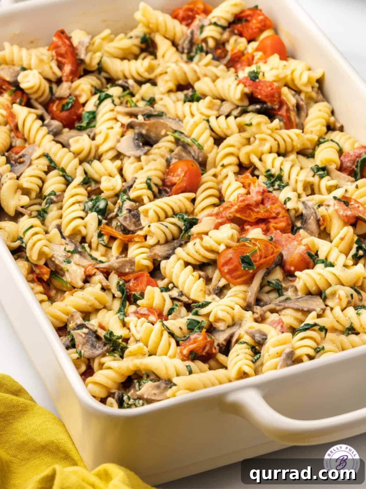Based on the viral TikTok recipe, Baked Boursin Pasta is made with rotini, veggies, and garlic and herb Boursin cheese. Ready in 35 minutes! Boursin pasta with vibrant roasted vegetables in a baking dish, ready to be mixed.