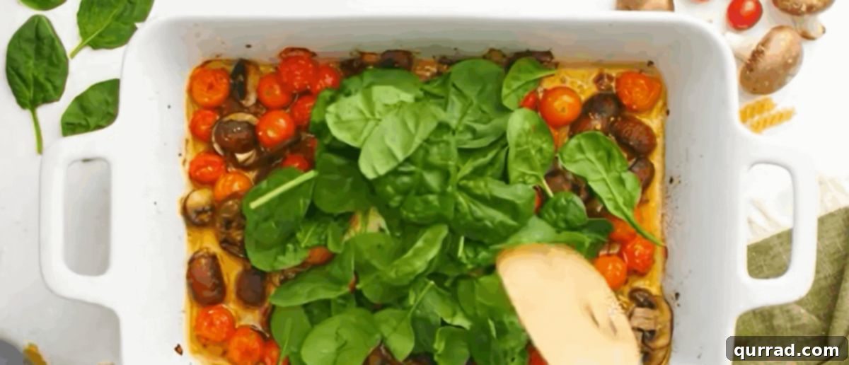 Velvety Boursin Garlic Herb Pasta 3 Adding spinach to the hot pan with the roasted veggies and melted Boursin cheese.