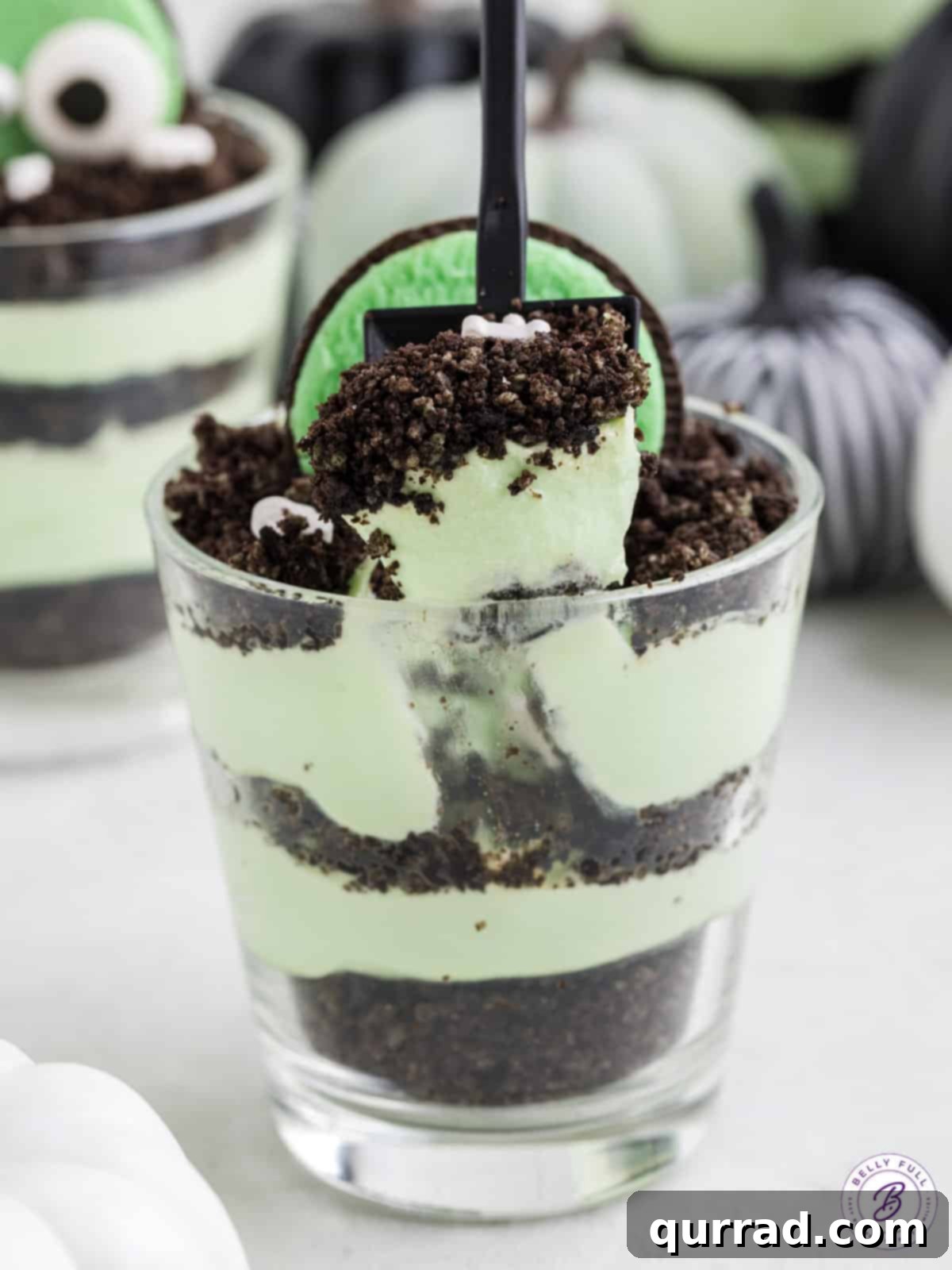 A Halloween dirt pudding cup on a kitchen countertop with a spooky background.