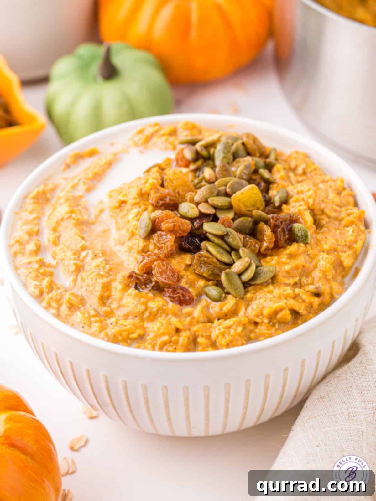 Pumpkin oatmeal is made with wholesome ingredients like oats and pumpkin puree and spiced with warm flavors of pumpkin pie spice, perfect for a hearty breakfast. An angled view of a bowl of pumpkin oatmeal, showcasing its creamy texture and inviting color.