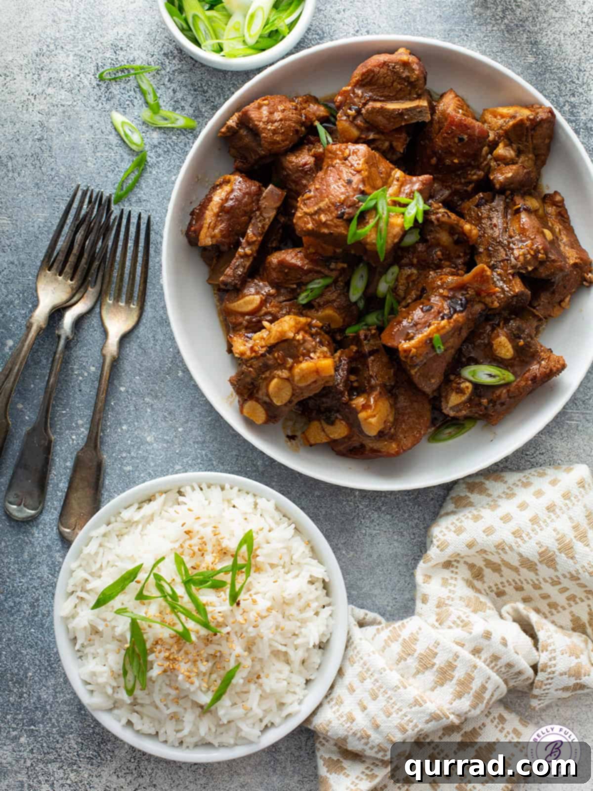 Sweet and Sticky Chinese Ribs 5 Chinese pork spare ribs in a bowl next to a bowl of white rice