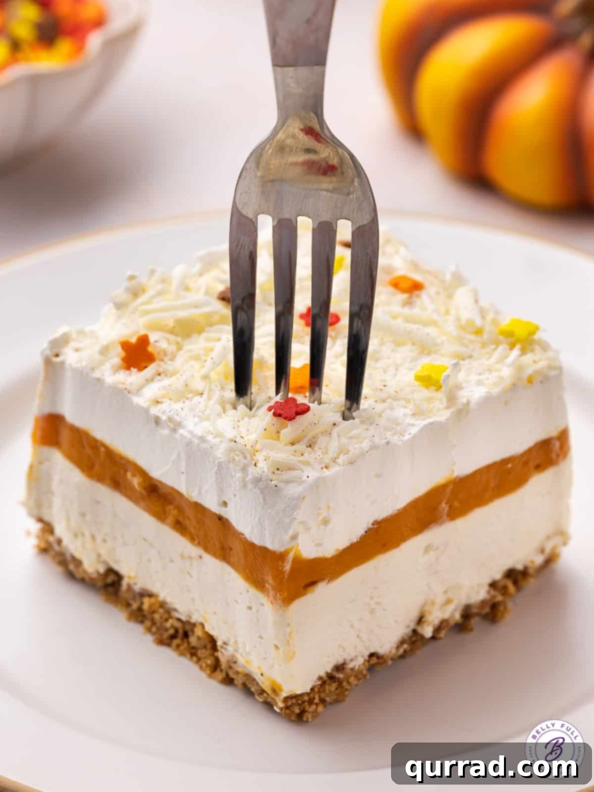 Enjoying a Slice of No-Bake Pumpkin Lasagna A fork poised to take a bite from a perfectly layered slice of pumpkin dessert lasagna, highlighting the distinct textures.