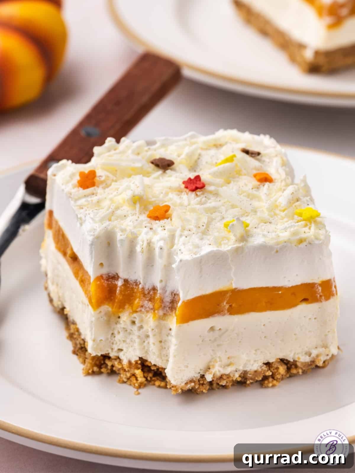 A Tempting Slice of Pumpkin Lasagna A slice of no-bake pumpkin dessert lasagna on a plate, with a small bite missing, illustrating its irresistible appeal.