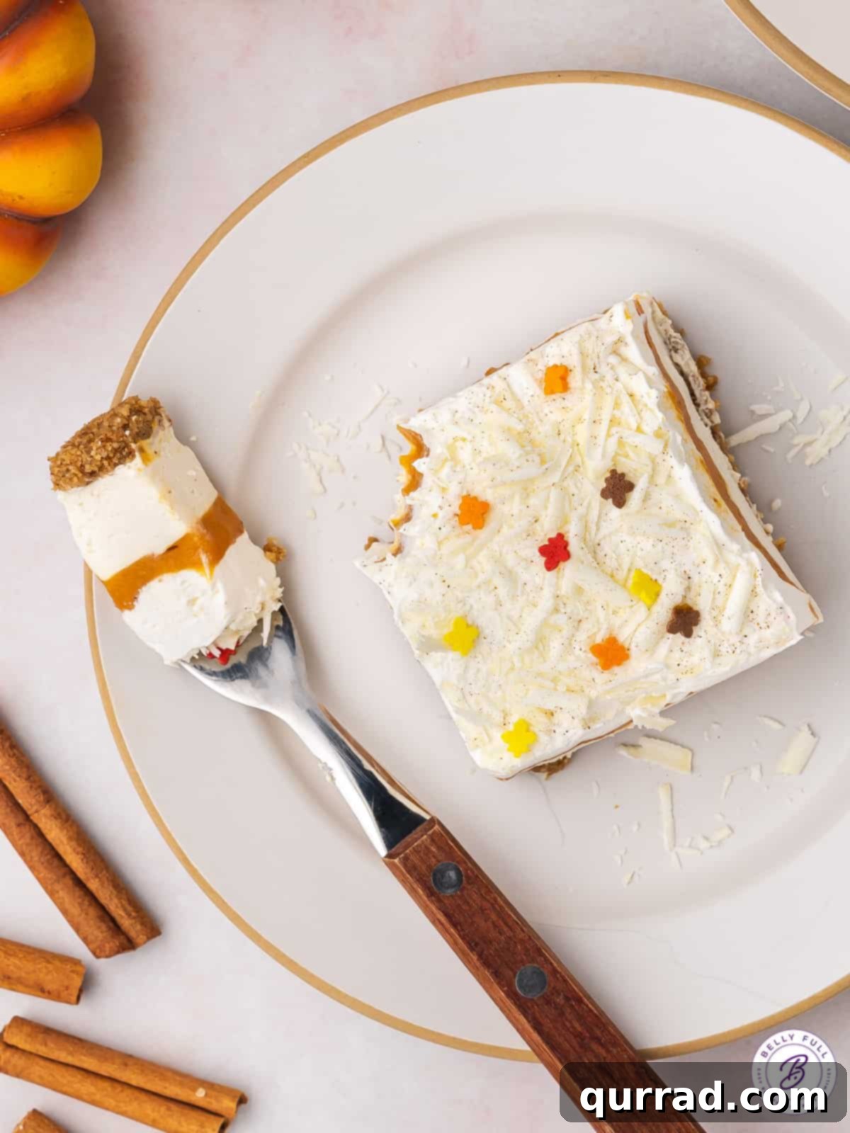 Perfectly Layered Pumpkin Lasagna Dessert Slice An overhead view of a beautifully sliced no-bake pumpkin lasagna dessert on a plate, with a fork holding a single, irresistible bite.