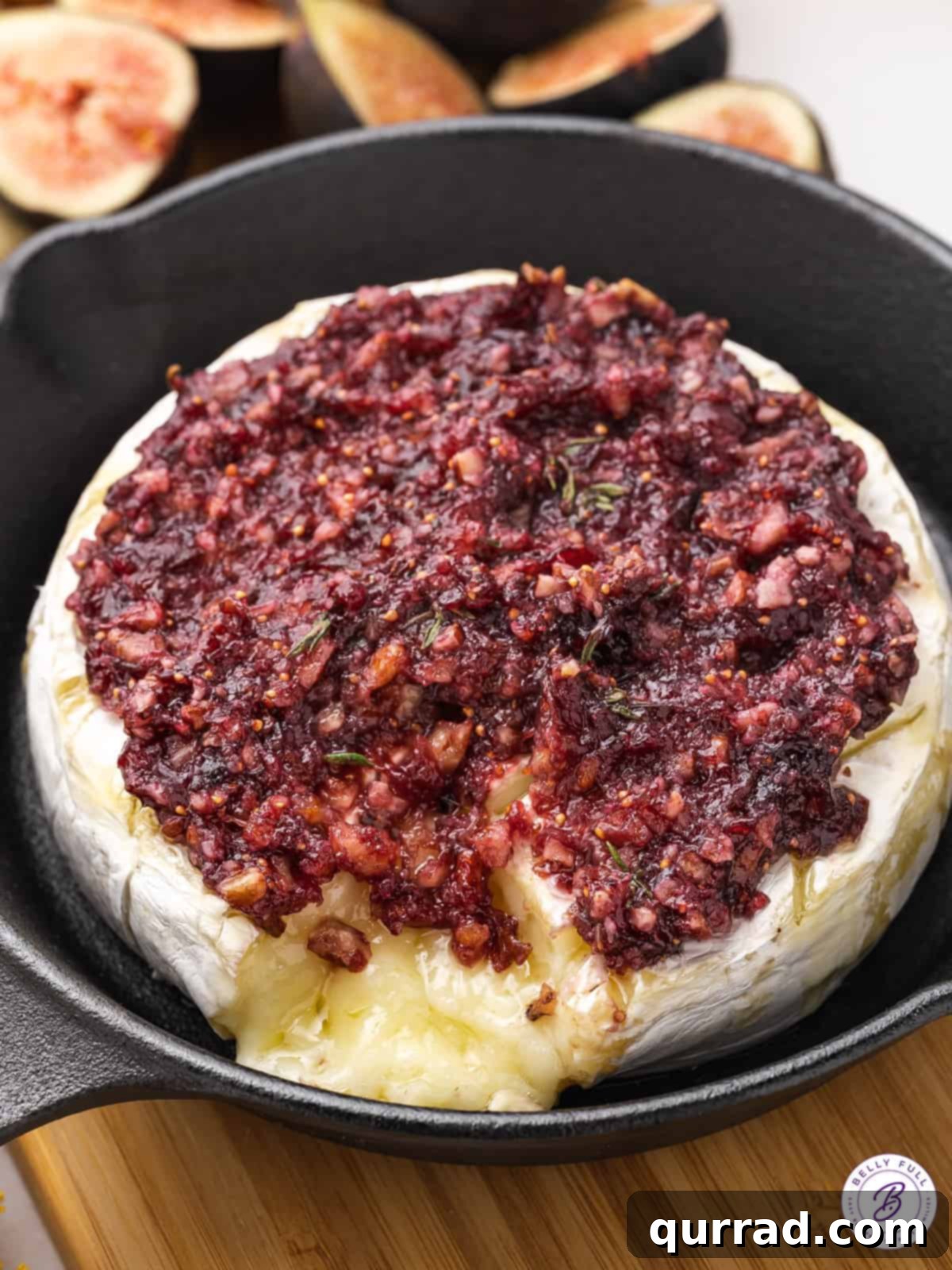 Baked brie with jam in a black cast iron skillet