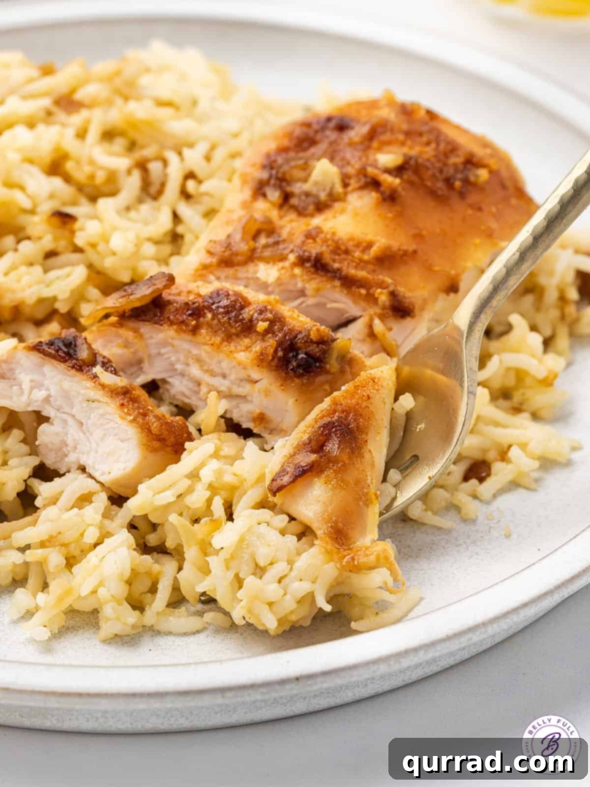 A close-up of a fork lifting a perfect bite of tender chicken and fluffy rice from the No-Peek Chicken and Rice Casserole.