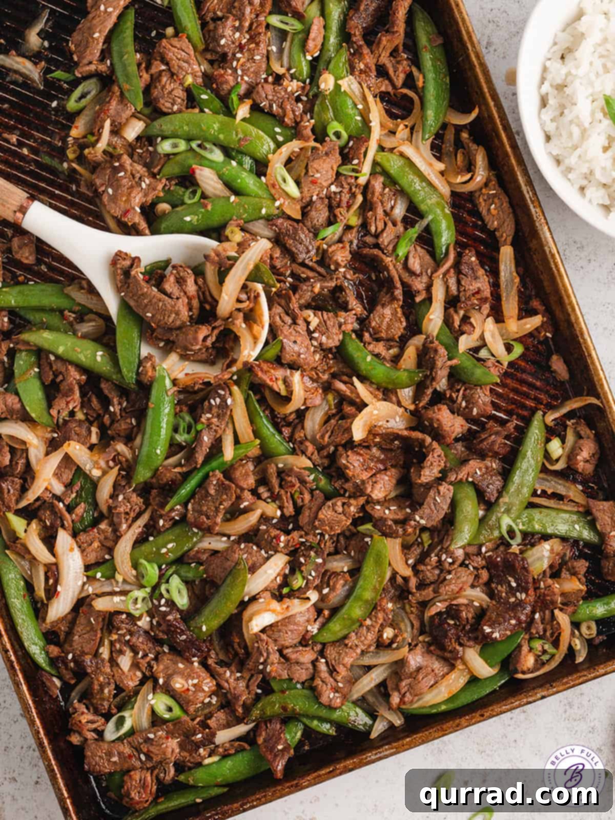 One-Pan Korean BBQ Beef 3 A spoon serving sheet pan beef bulgogi with vegetables over rice