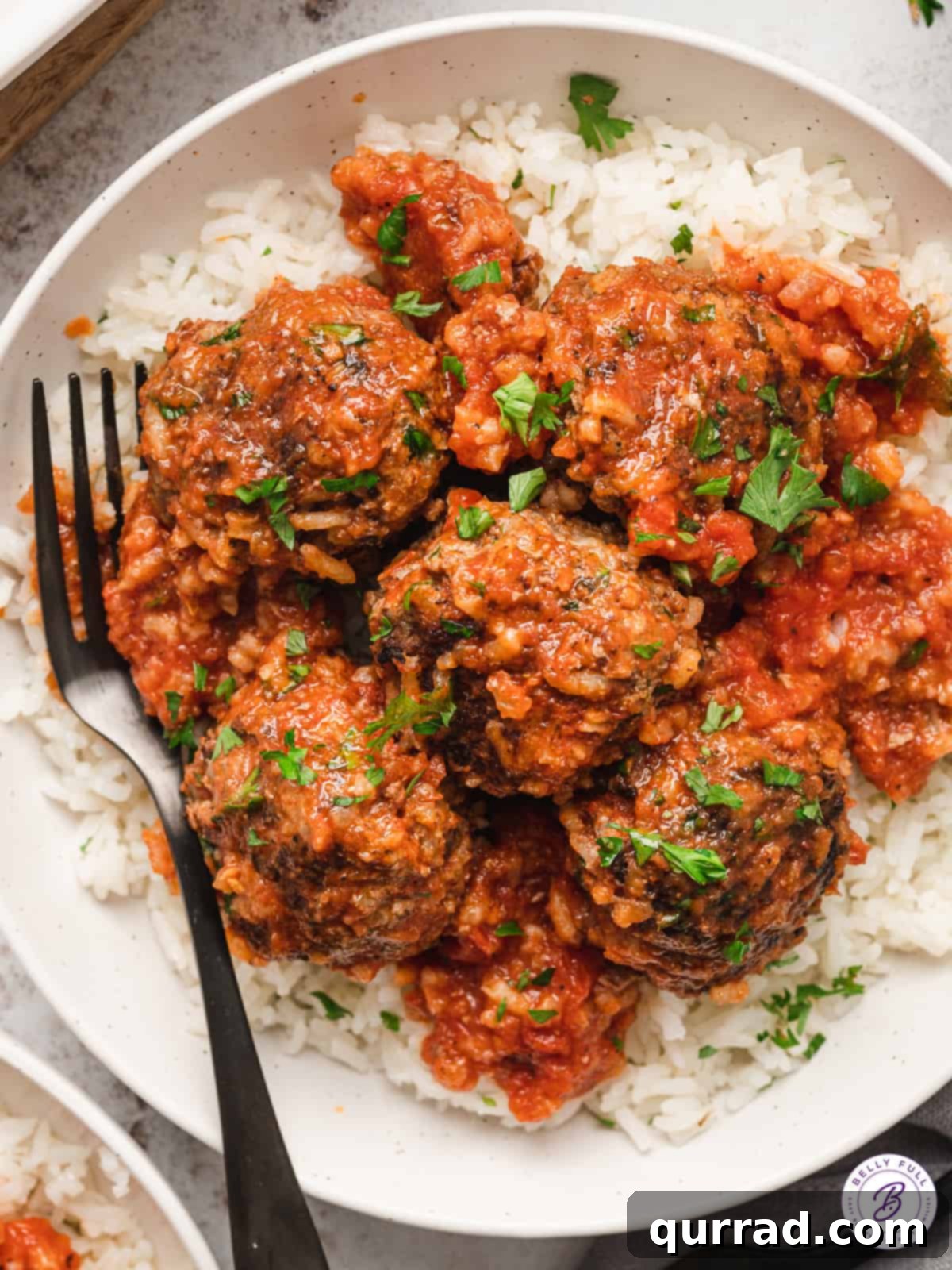 Overhead view of porcupine meatballs on a plate of rice, showcasing their unique texture