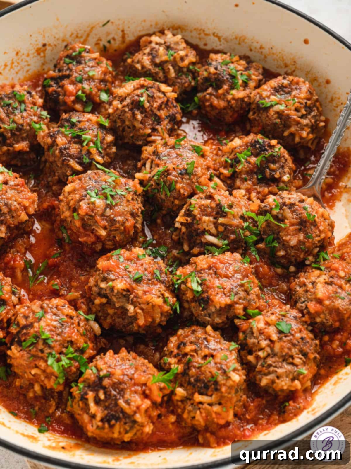 Meatballs with rice simmering in a savory tomato sauce in a saucepan