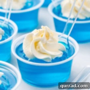 Jack Frost Jello Shots with whipped cream and tasting spoon