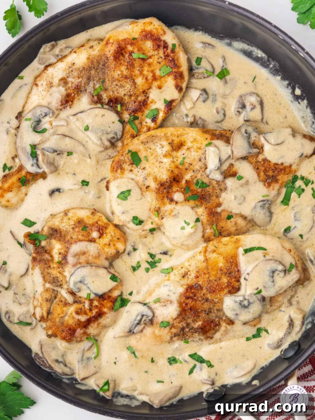Boursin Chicken: A simple, restaurant-quality weeknight dinner with juicy chicken breasts, mushrooms, and a garlic herb Boursin cheese white wine sauce. Overhead view of Boursin cheese chicken in a skillet, garnished with fresh herbs.
