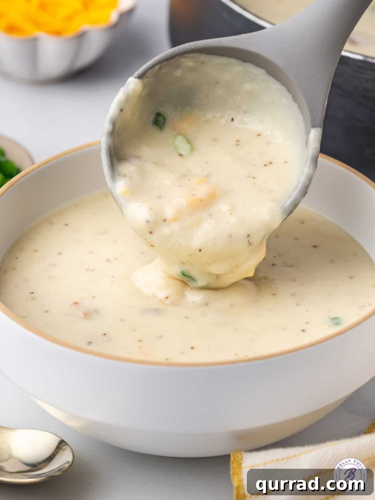 Copycat Panera Baked Potato Soup is rich, creamy, and full of incredible flavor, thanks to ingredients like cream cheese and bacon. A ladle expertly spooning steaming baked potato soup into a serving bowl, ready for garnishes.