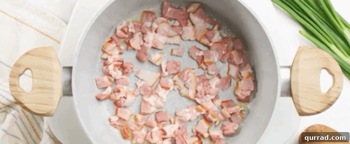 Creamy Roasted Potato Soup 3 Cooking diced bacon in melted butter in a large pot, creating a savory base for the soup.