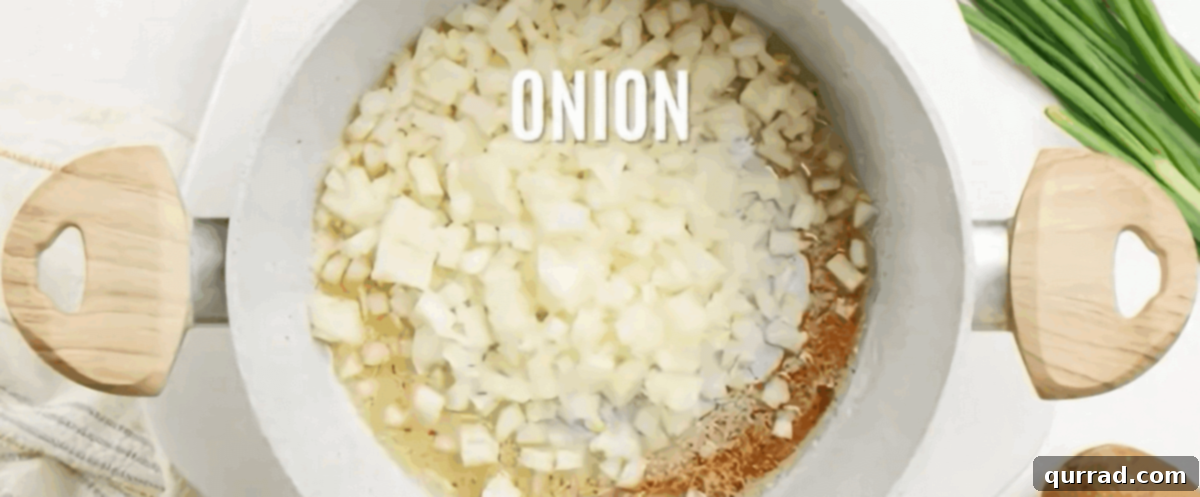 Creamy Roasted Potato Soup 4 Sautéing diced yellow onions and white scallion parts in the same pot after removing bacon, softening them for the soup base.