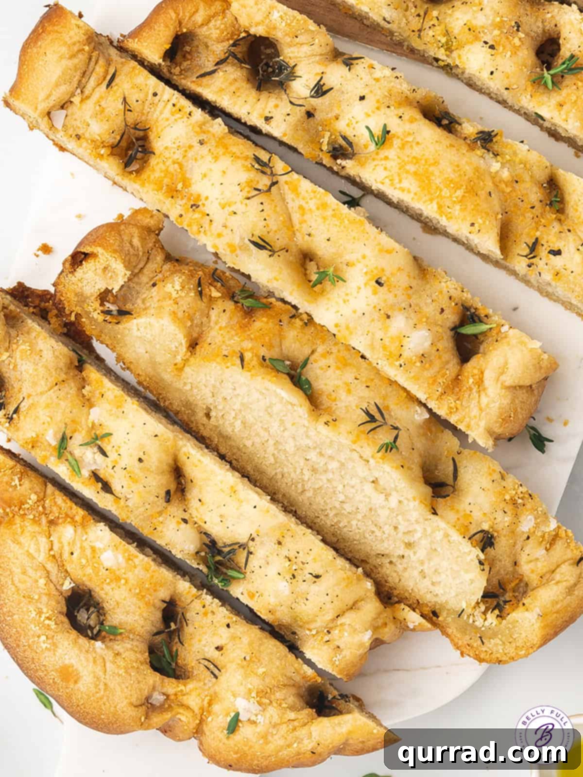 Freshly baked slices of slow cooker focaccia, showing a light and airy interior and a golden crust, ready to be enjoyed.