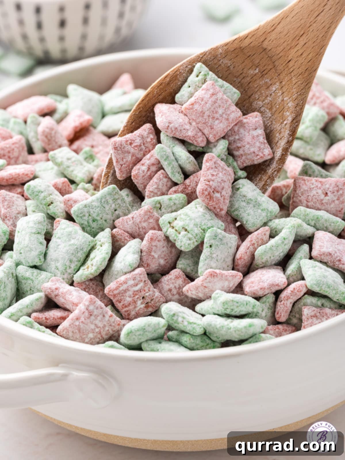 Santa's Sweet Snow Bites 4 Red and green puppy chow being carefully poured into a festive bowl