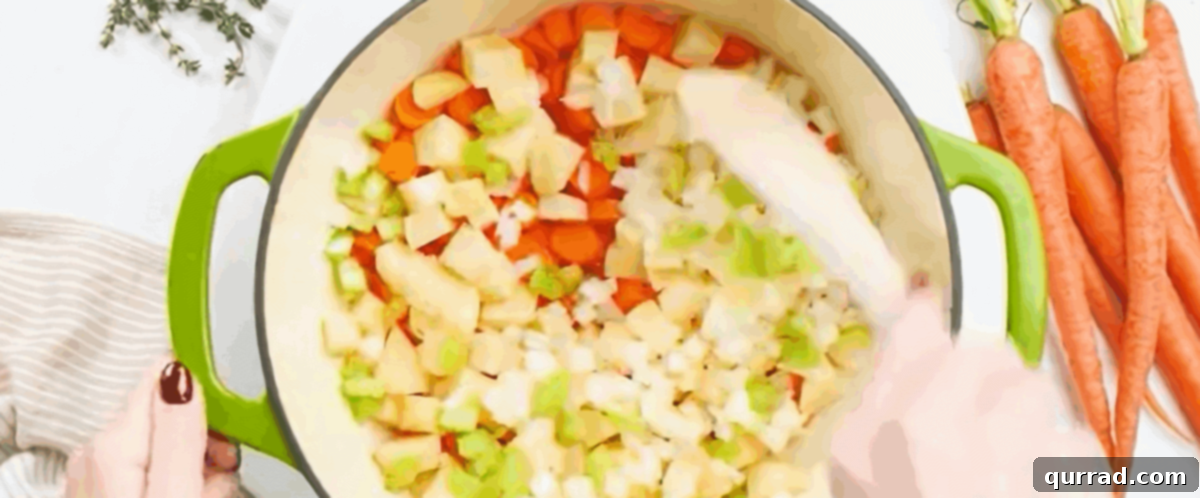 Cooking carrots, celery and onions in a pot with melted butter.