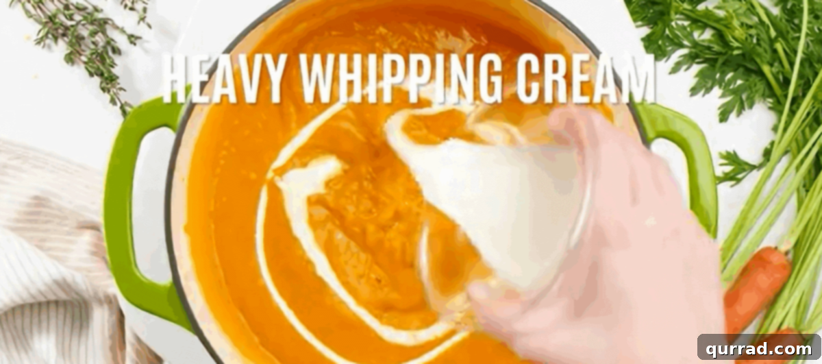 Adding heavy cream and seasonings to the blended carrot soup.