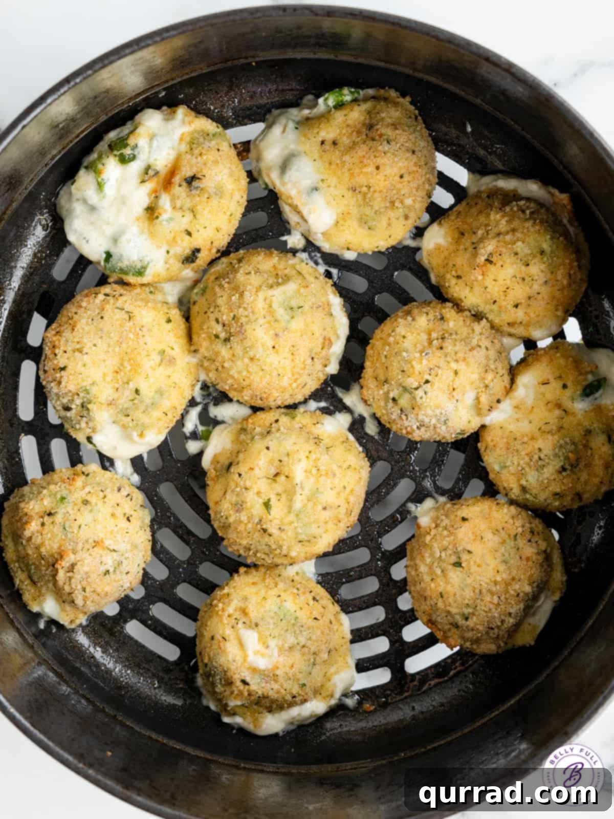Golden brown Rattlesnake Bites fresh from the air fryer. A batch of Texas Roadhouse rattlesnake bites cooking in an air fryer basket.