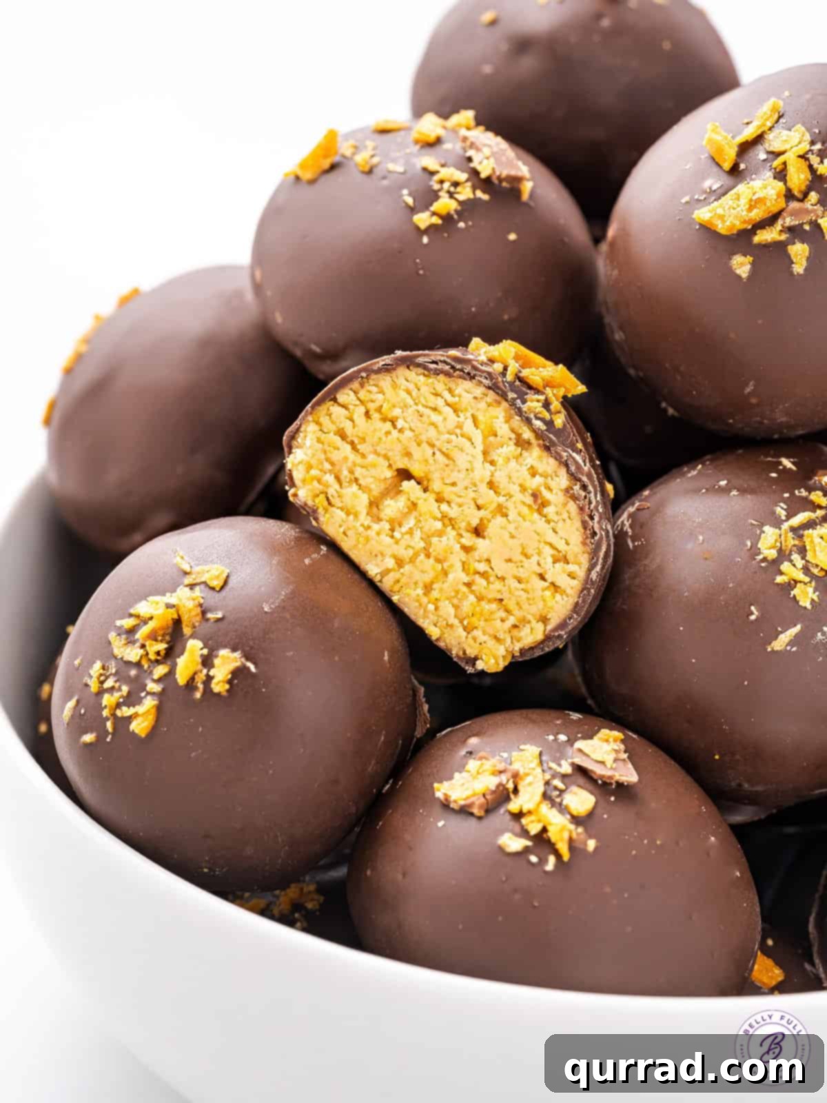 A cross-section of a Butterfinger Truffle revealing the creamy peanut butter filling studded with crispy cereal, perfectly encased in a smooth chocolate shell.