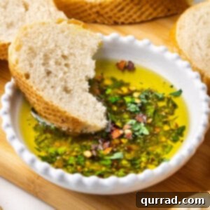 A bowl of bread dipping oil with a piece of crusty bread dipped into it.
