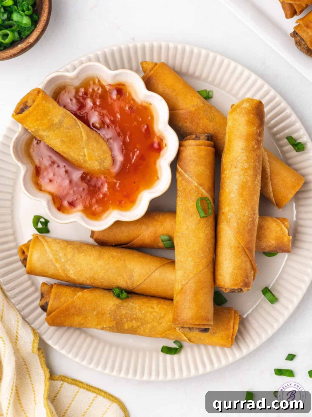 This lumpia recipe features a ground pork and water chestnut filling in a thin wrapper that's fried to perfection. Overhead view of a plate of lumpia with a dish of sweet chili sauce