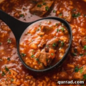 A smaller image of tomato and rice soup with a ladle.