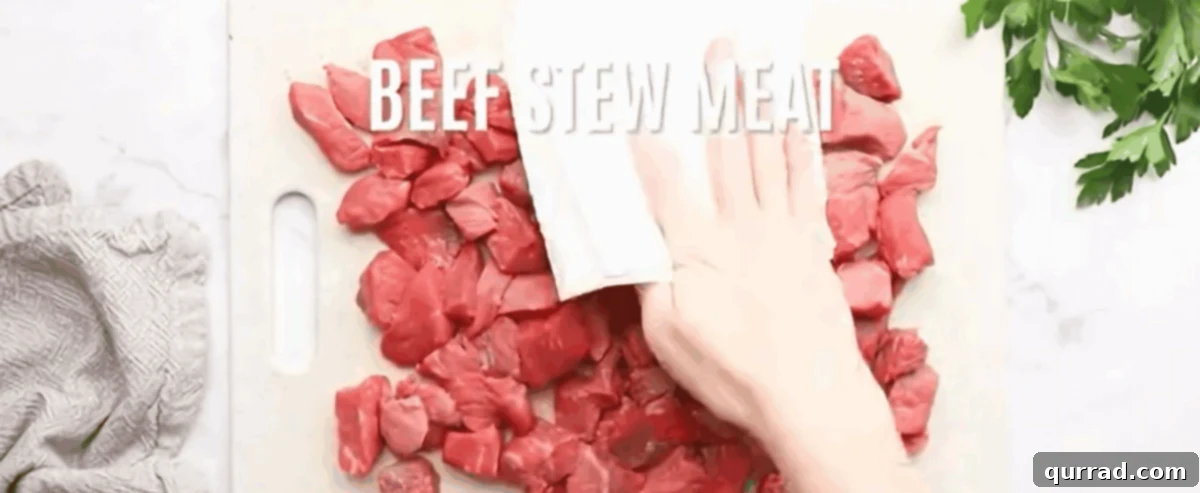 Patting beef stew meat dry with a paper towel before cooking.