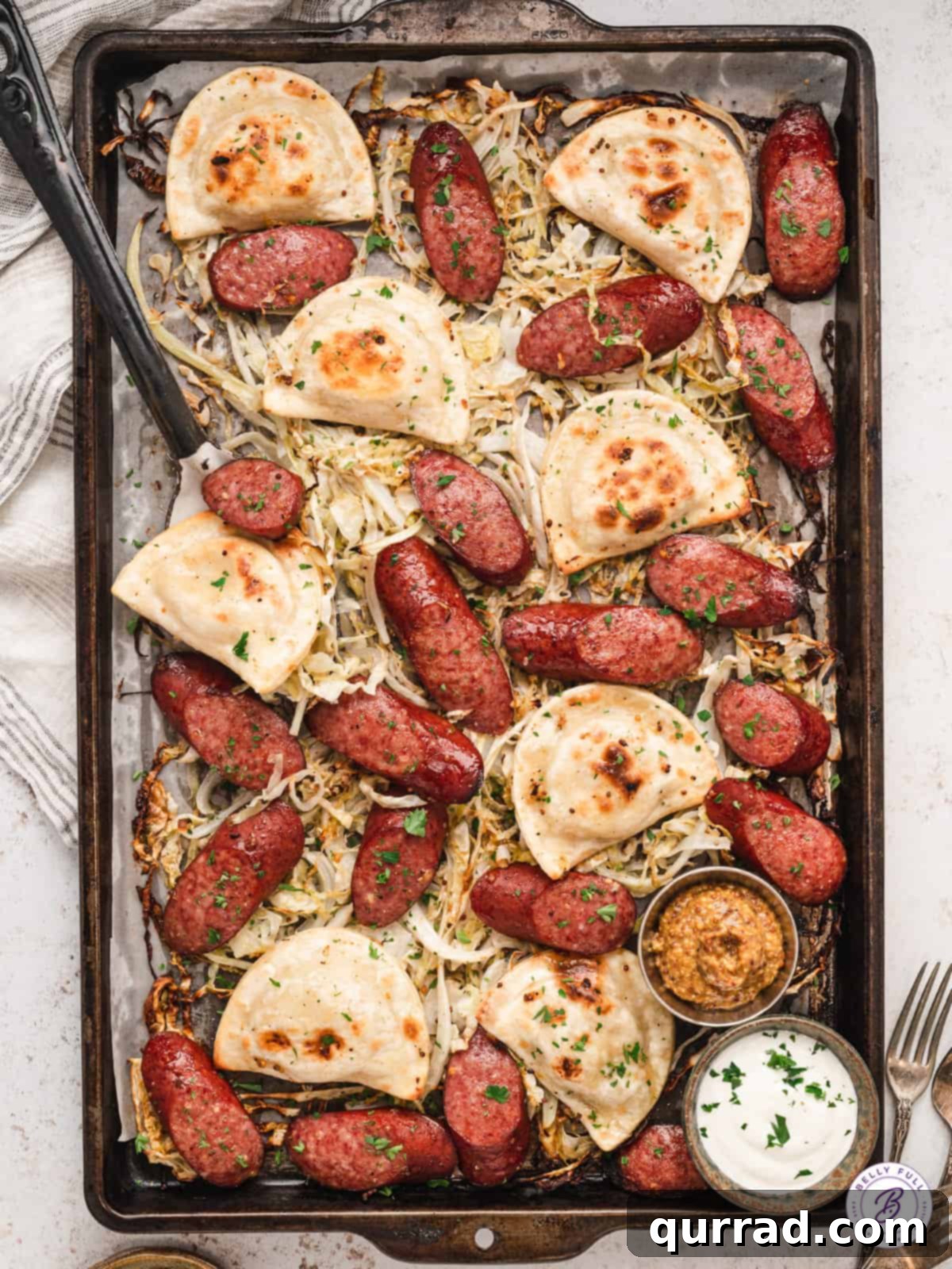 Overhead view of a vibrant Sheet Pan Pierogi and Sausage dinner with golden pierogi, sliced smoked sausage, and tender cabbage