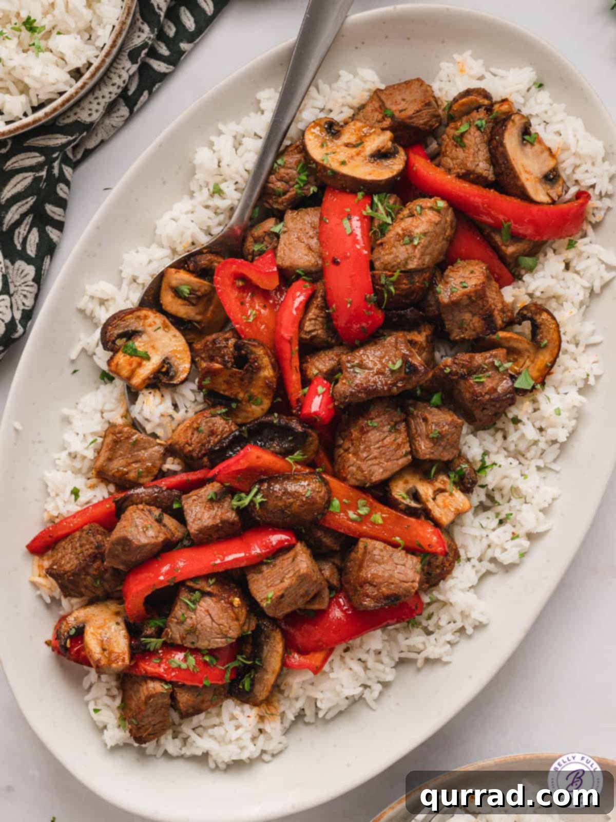 Quick Air Fryer Steak and Roasted Vegetables 5 Overhead view of air fryer steak bites and veggies on a platter of white rice