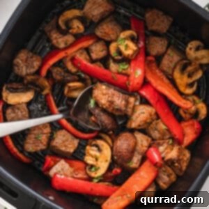 A spoon in air fryer steak and veggies