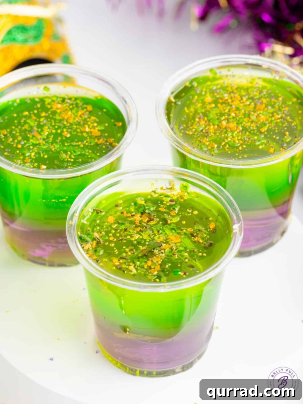 layered purple, green, and gold jello shots