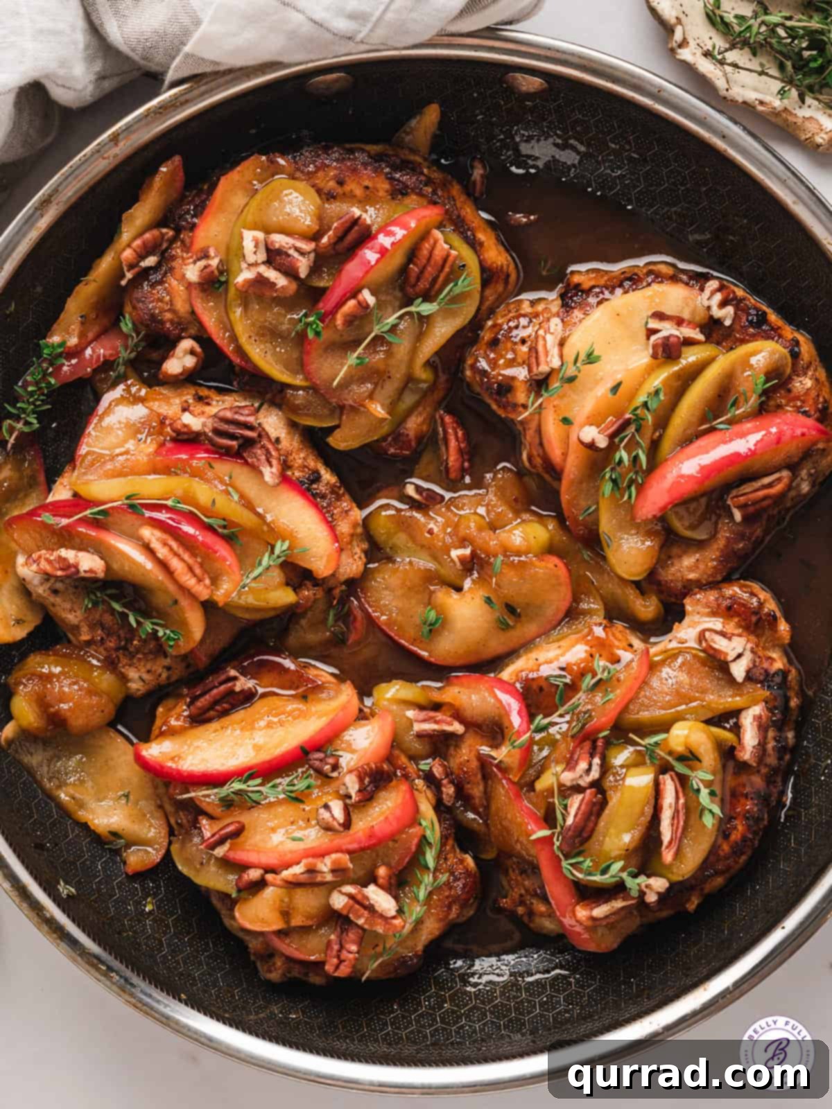 Juicy boneless pork chops with sweet caramelized apples – a simple, one-pan delight. Overhead view of apples with perfectly cooked pork chops in a rustic skillet, ready to serve.