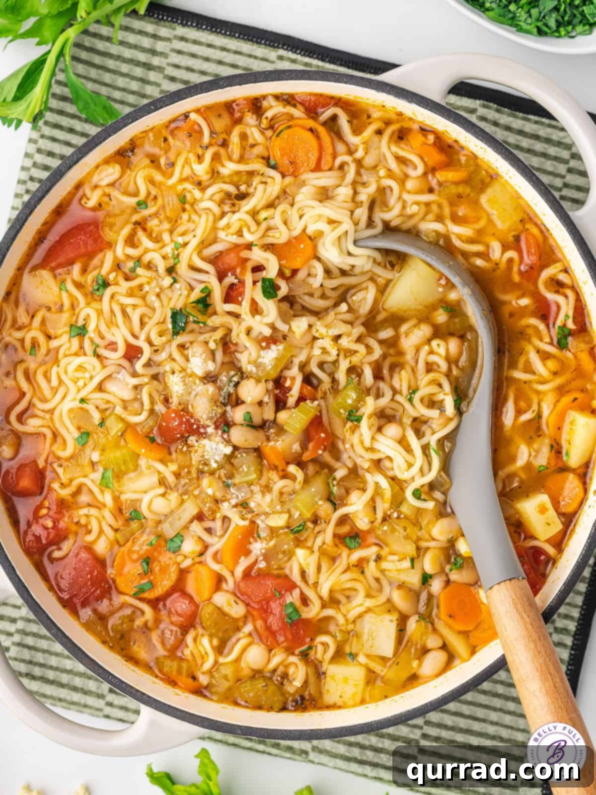 A spoon in a pot of Italian ramen noodle soup