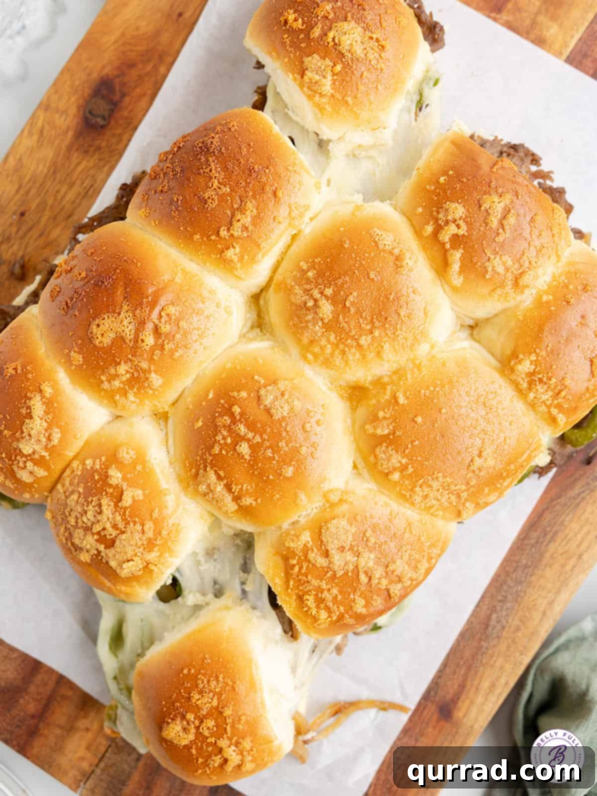 Ultimate Philly Slider Melts 5 Overhead shot of freshly baked Philly Cheesesteak Sliders on a cutting board, ready to be served.