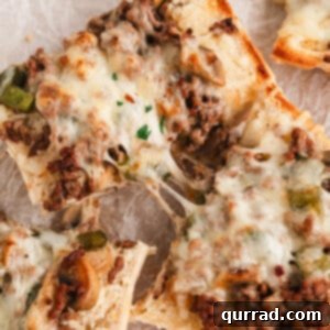 Two slices of Philly cheesesteak bread being pulled apart