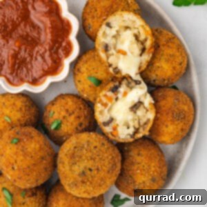 A plate of golden-fried arancini, showcasing its delicious texture.