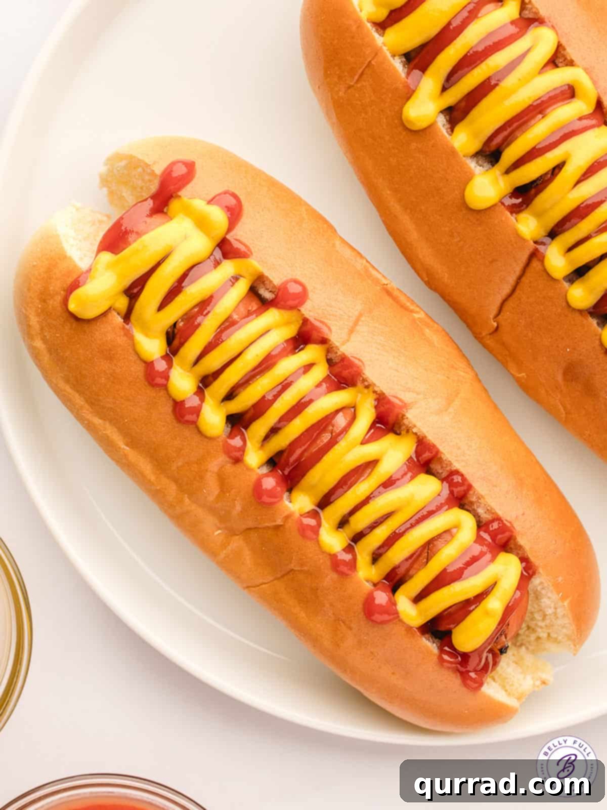 Golden Air Fryer Hot Dogs 5 hot dogs in buns with mustard on plate
