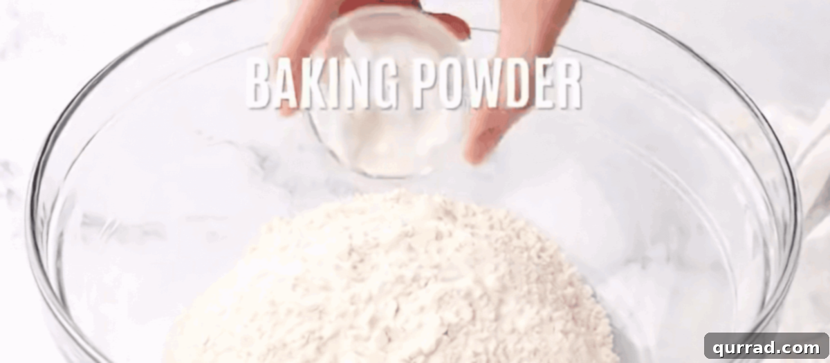 Buttery Flaky Homemade Biscuits 3 Combining the dry ingredients (flour, baking powder, sugar, salt) for the biscuits in a clear glass mixing bowl.