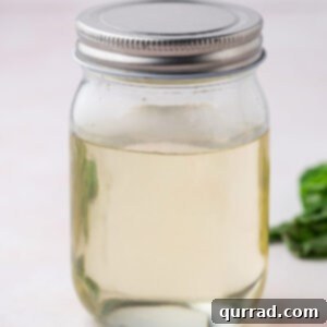 A glass jar of basil infused simple syrup