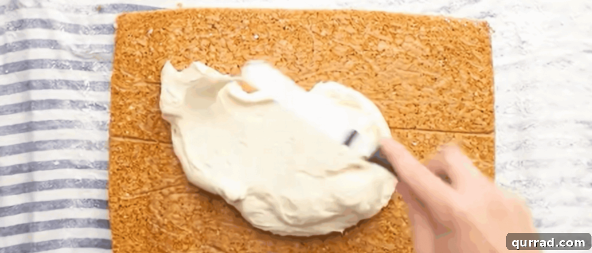 Spiced Carrot Cake Roulade 10 Spreading the rich cream cheese frosting evenly over the unrolled carrot cake, leaving a border.