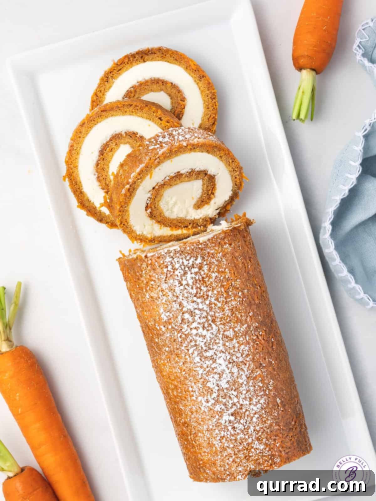 Spiced Carrot Cake Roulade 12 A beautifully presented carrot cake roll on a serving platter with three perfect slices already cut, ready to enjoy.