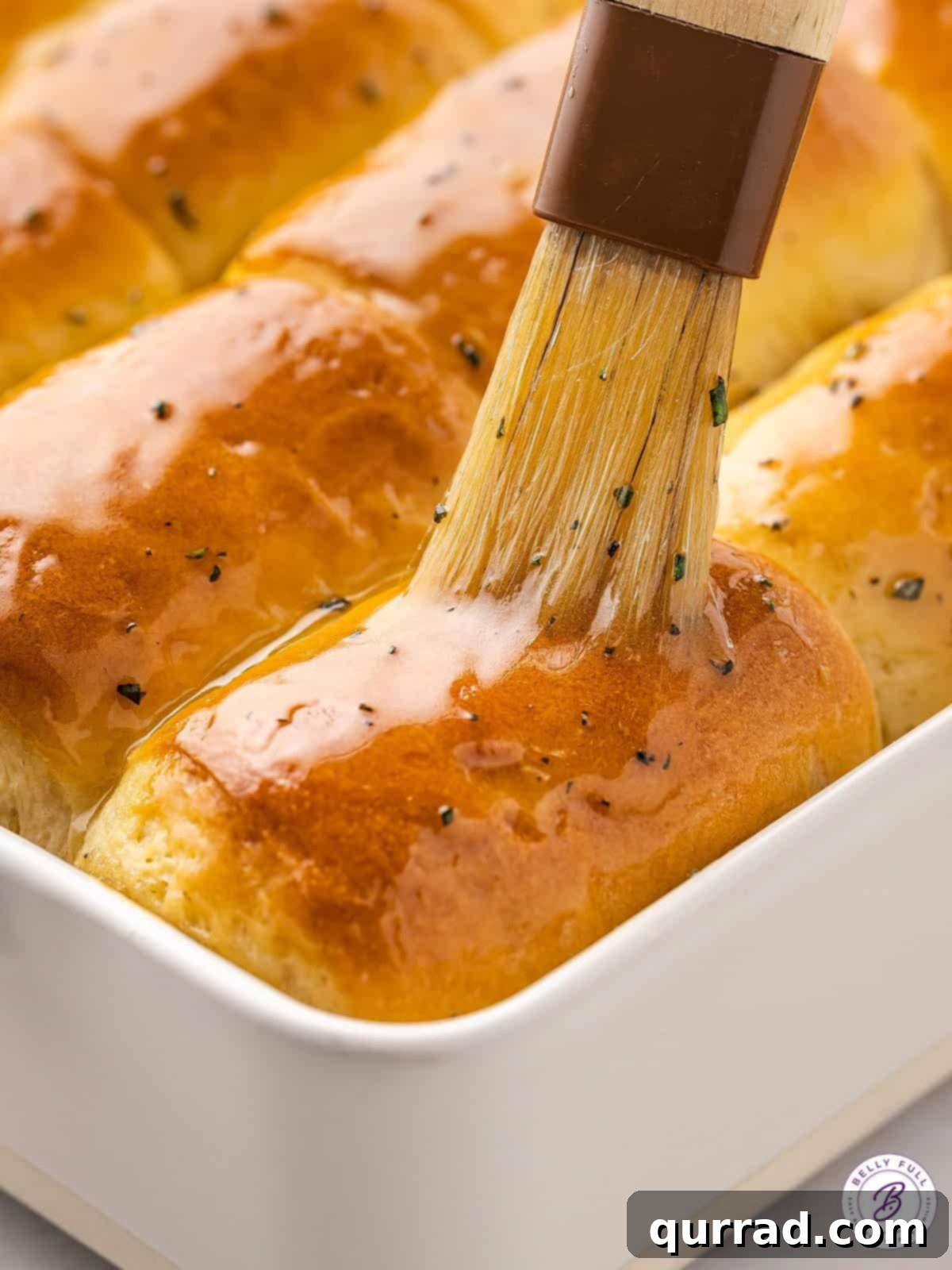 Glazing Warm Parker House Rolls for Extra Flavor and Shine Brushing a generous layer of honey rosemary glaze over freshly cooked, warm Parker House rolls.