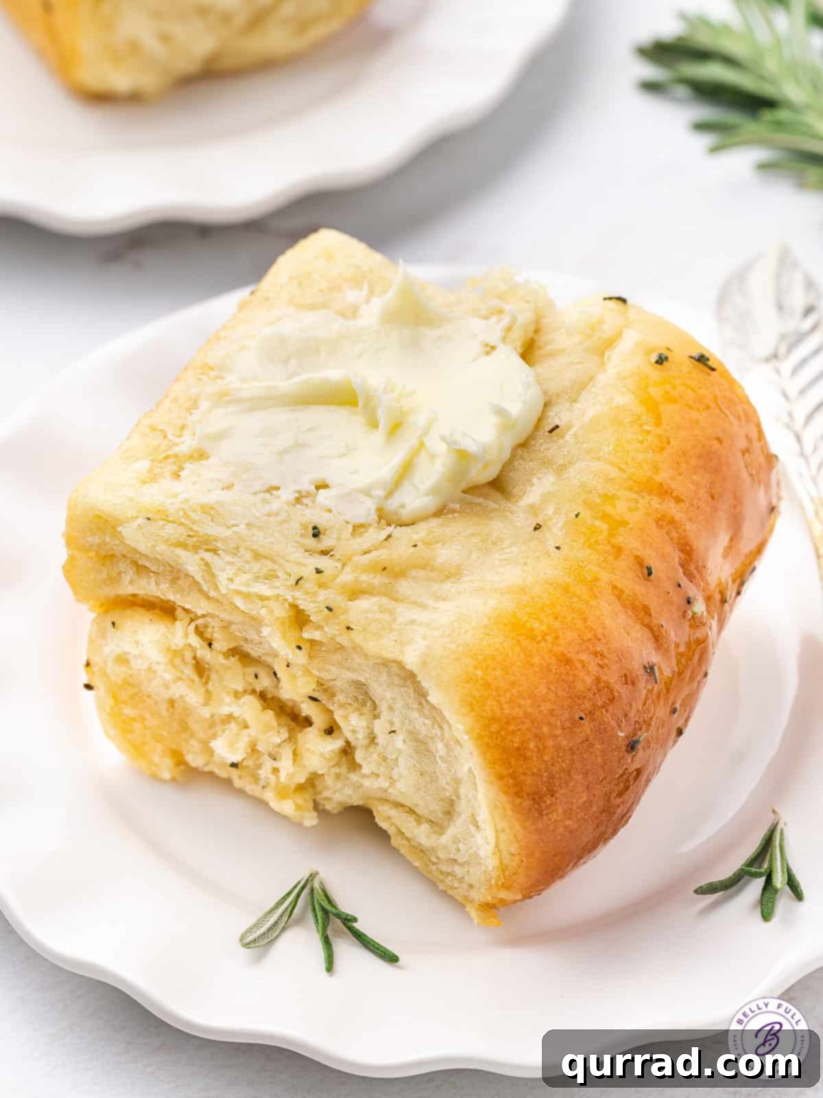 Decadent Parker House Roll with Butter A close-up of a Parker House roll, perfectly split to reveal its soft, buttery interior, with a golden exterior.