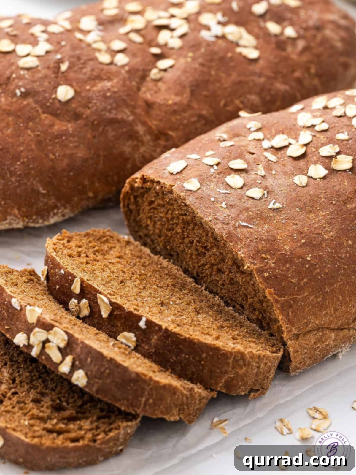 Freshly baked Copycat Cheesecake Factory brown bread with three pieces sliced, showcasing its inviting color and texture.