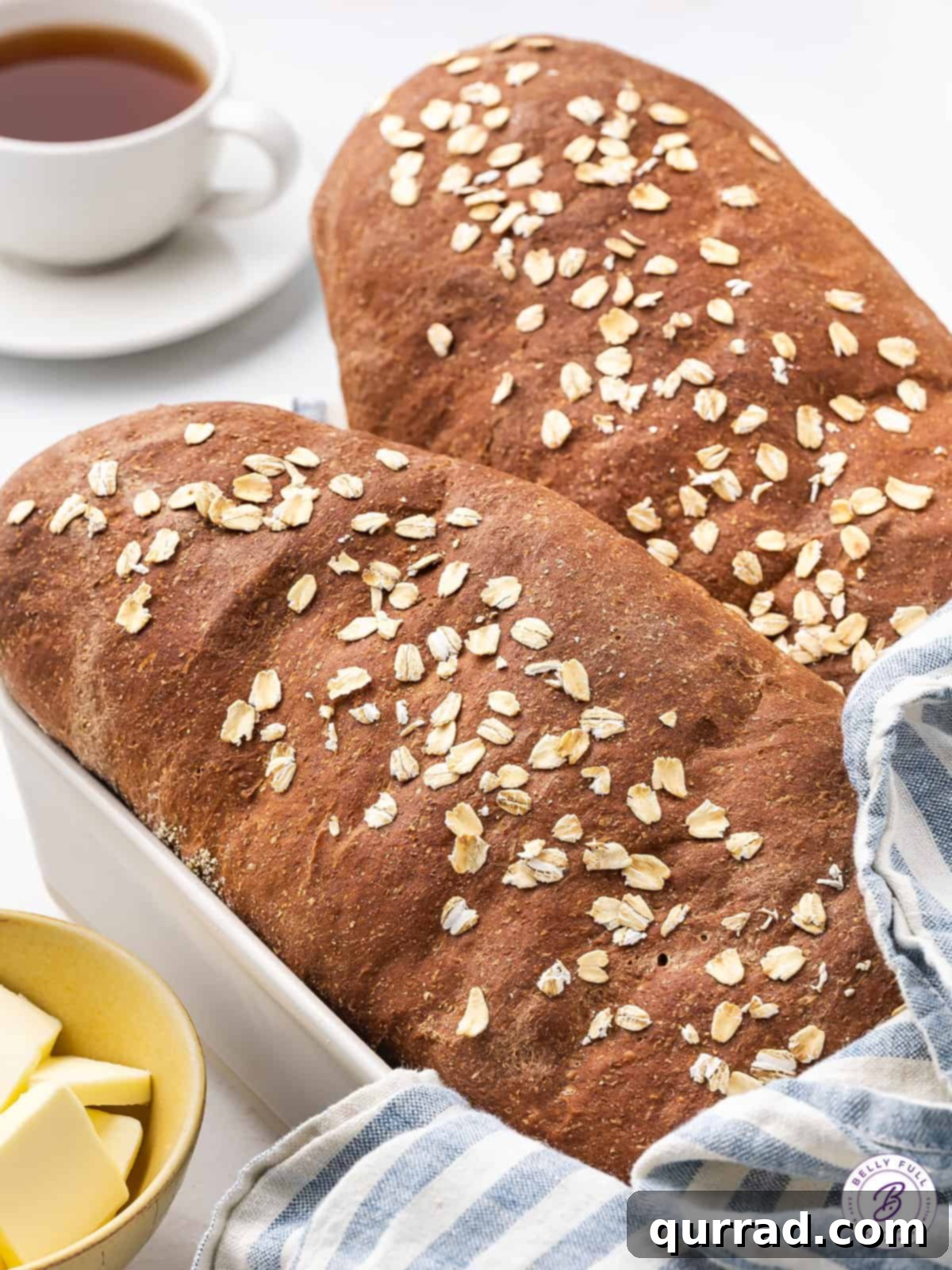 Two freshly baked loaves of brown bread, ready to be sliced and served.