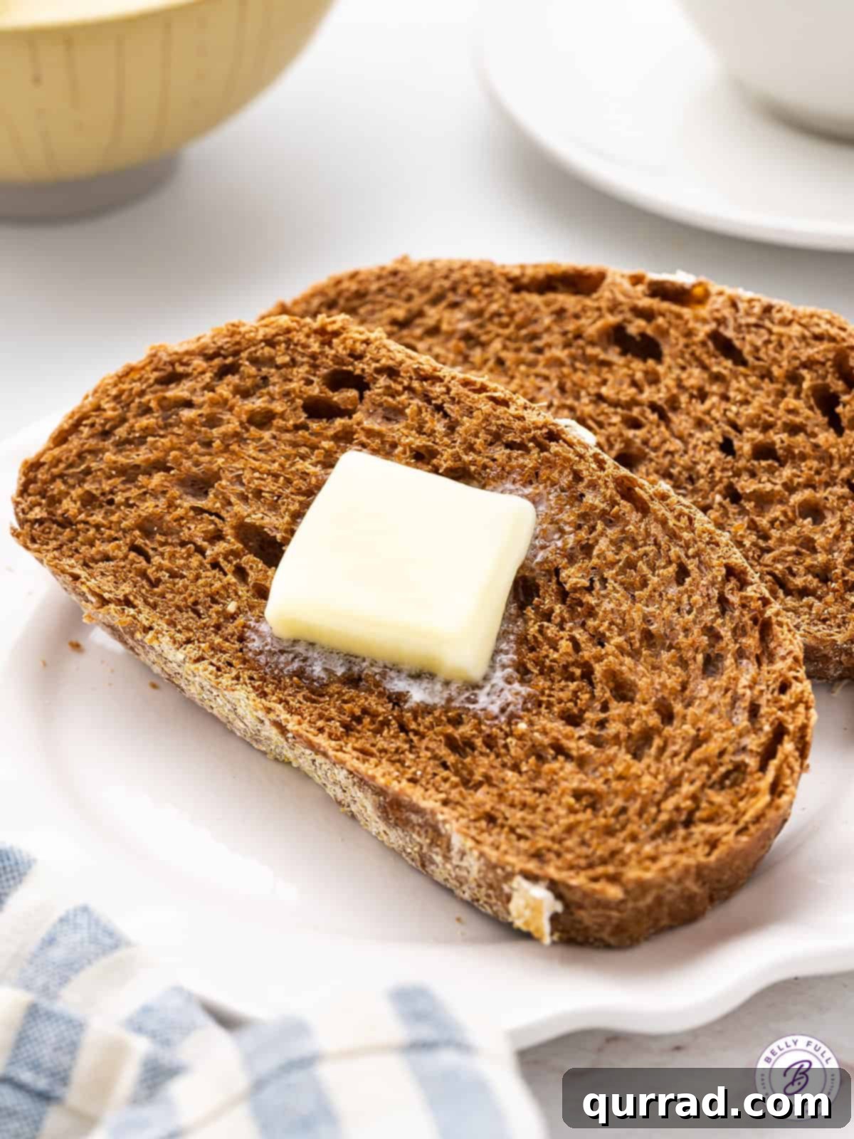 Two slices of warm, inviting Cheesecake Factory brown bread, perfectly complemented with softened butter.