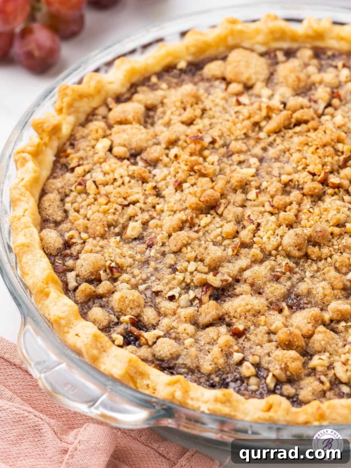 Perfectly Baked Grape Pie A freshly baked grape pie, still in its dish, showcasing the golden streusel topping and perfectly set filling.