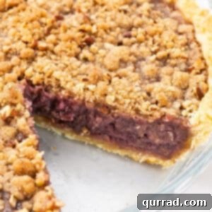 A freshly baked grape pie with a golden streusel topping, showcasing its delicious texture.